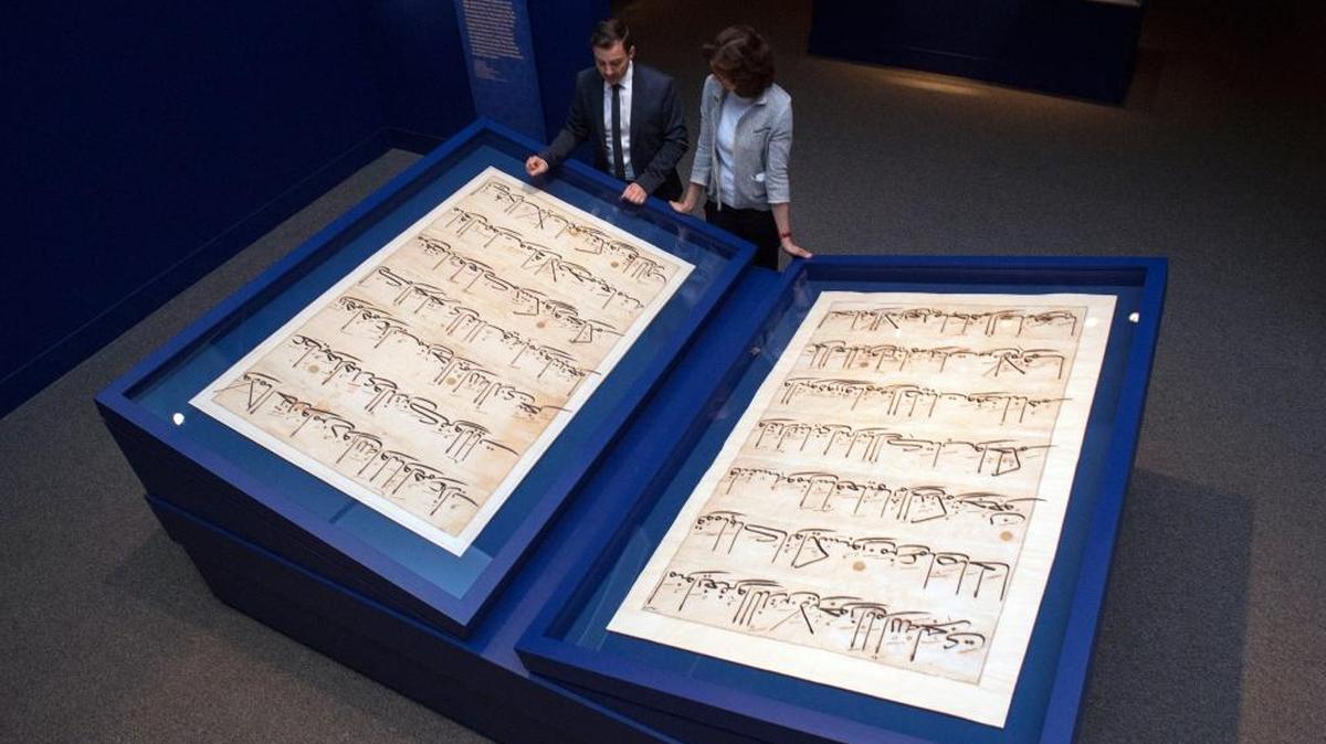 Simon Rettig, left, and Massumeh Farhad, curators of the exhibit "The Art of the Qur'an: Treasures from the Museum of Turkish and Islamic Arts," look at pages from a 5-foot by 7-foot Quran displayed as part of the exhibit at the Sackler Gallery in Washington.