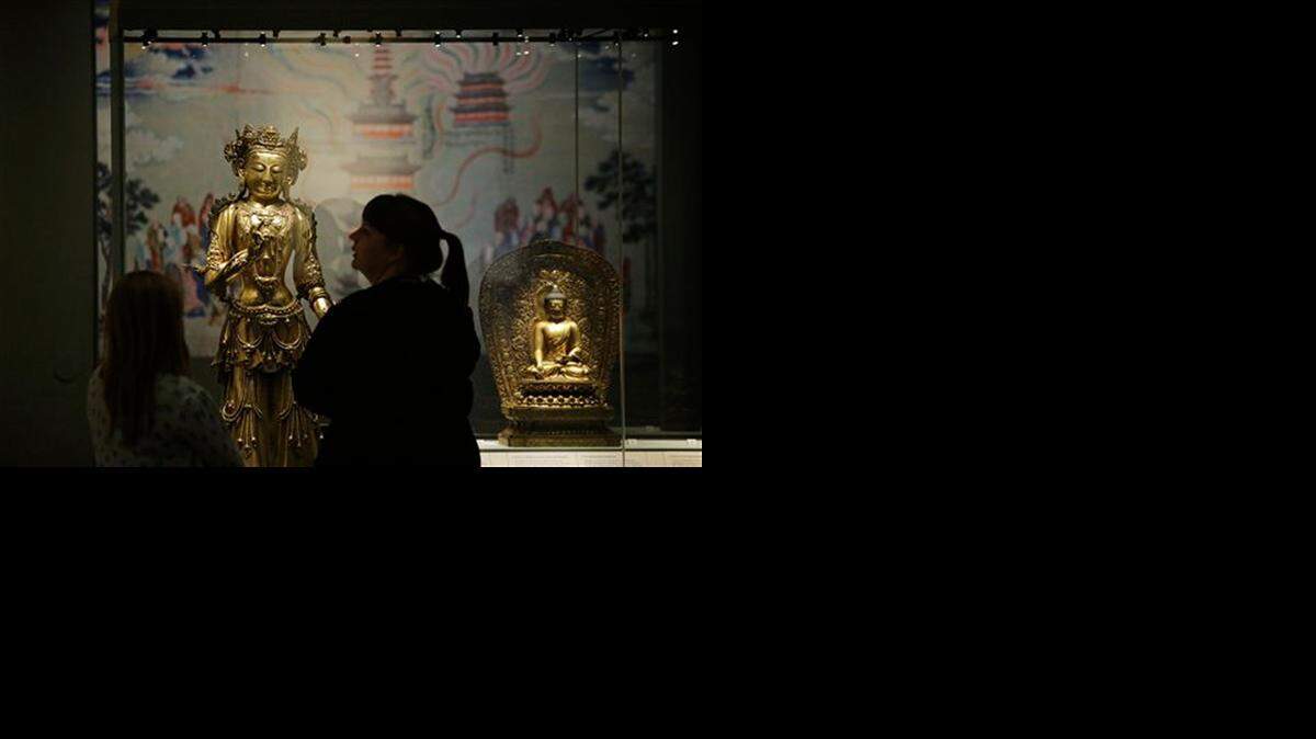 
Visitors view gilded bronze sculptures of the Avalokitesvara, the enlightened being destined for Buddhanhood most often worshipped in China, at the British Museum in central London. 

