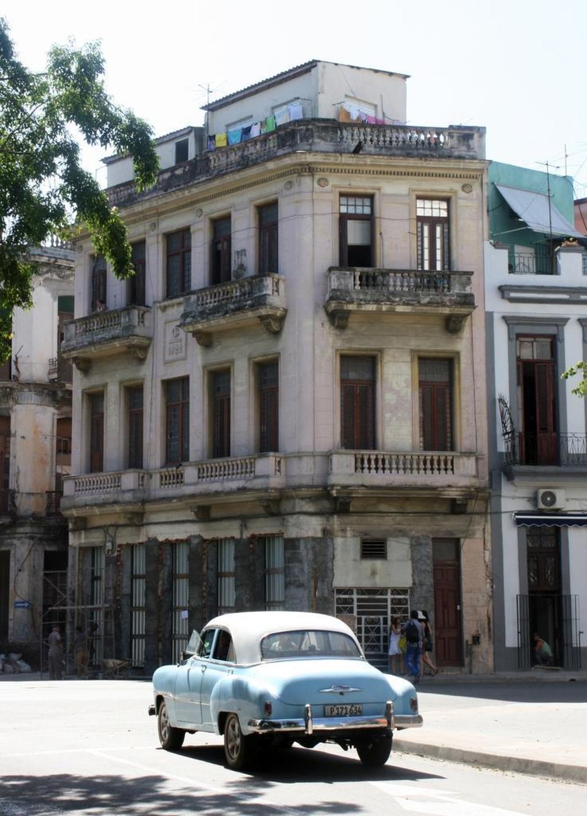 Near the former presidential palace, two Havana icons — a classic car and a deteriorating building.