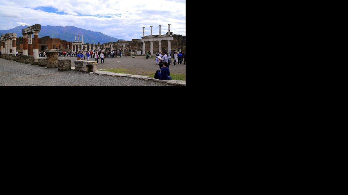 
Tourists stroll past the remains of Pompeii's forum.
