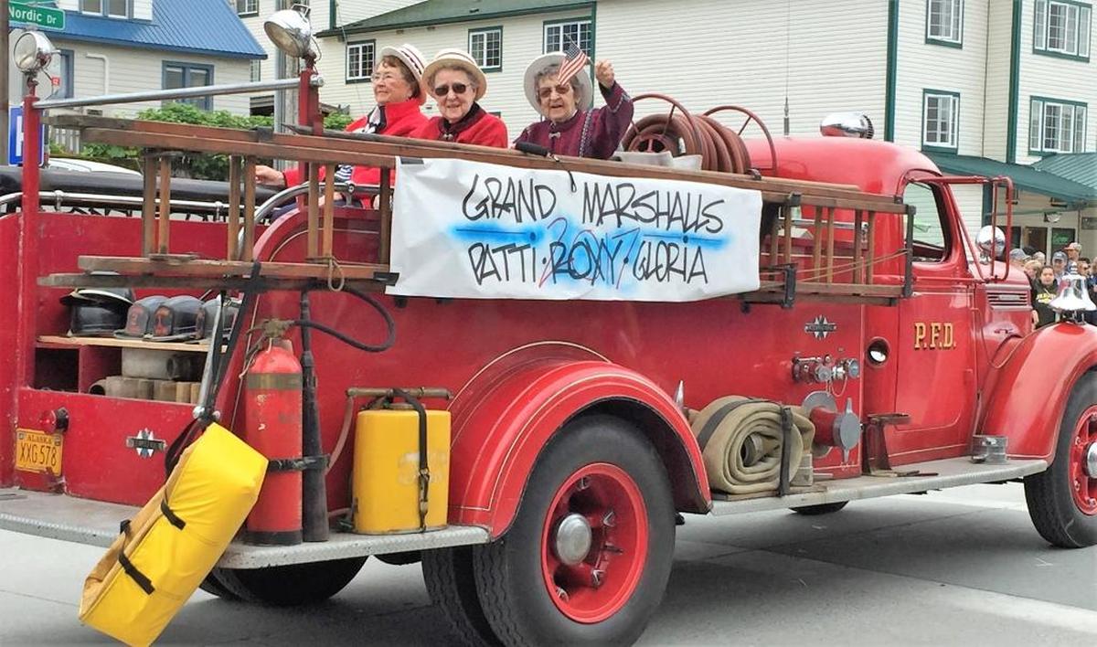 Three grand marshals wave their flags in the July 4 parade in Petersburg, Alaska.