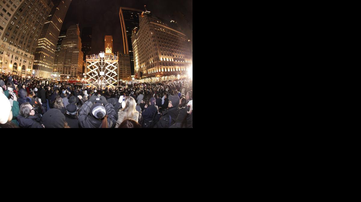 
People gather around the world’s largest Hanukkah menorah on Fifth Avenue and 59th Street near Central Park in New York in 2013. This year’s menorah will be lit nightly Dec. 16-23 in the same location. 

