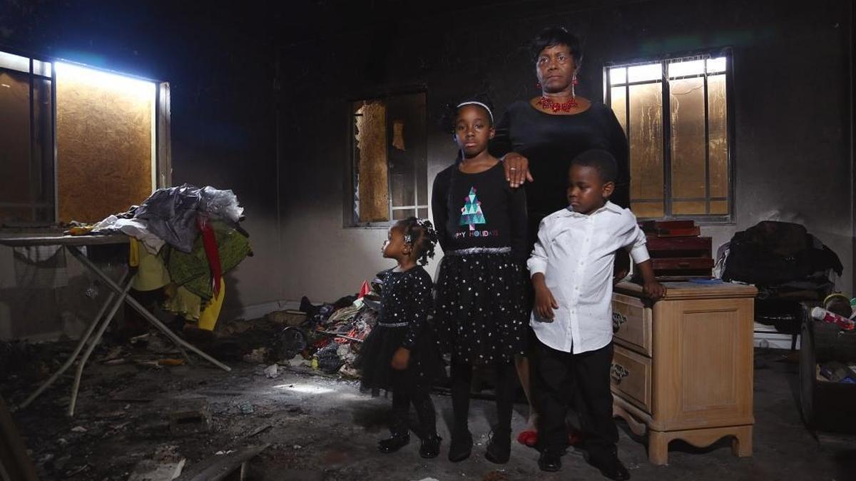 Melissa Allen, a grandmother of three young children — Josiah, 5, Alanah, 8, and Aliyah, 2 — needs some financial help after a fire burned her home and destroyed most of her belongings. Allen stands with her grandchildren inside her fire-damaged bedroom on Sunday, Dec. 3, 2017.