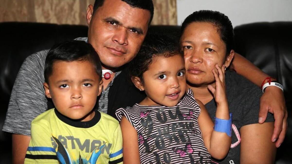 José Chávez, with his wife, Marilú Berrios, and their 4-year-old twins, Atzel and Itzel. Chávez had to have a tracheal tube inserted after he was wounded in the neck in a drive-by shooting. The April shooting has left the family with mounting bills, and a crippling fear.