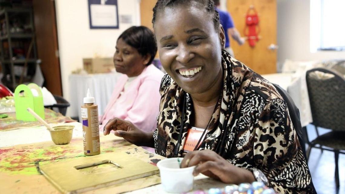Shamill Ferdinand, right, flashes her signature smile during an arts and crafts session at the Miami Lighthouse for the Blind and Visually Impaired on Friday, Dec. 9, 2016 in Miami. Ferdinand, 39, was born with one eye and now has very limited eyesight. Unable to work much and nearly penniless, she’s hoping for a radio/CD player and a voice-driven laptop, provided through Miami Herald Wish Book reader donations. Ferdinand is a client of the Miami Lighthouse for the Blind, where she regularly spends her Fridays, and hopes soon to spend each weekday.