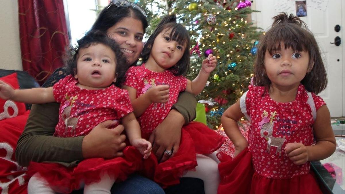Natalie Roy with adoptive daughters Sofia, left, Luna and Isabella at their home in South Dade.