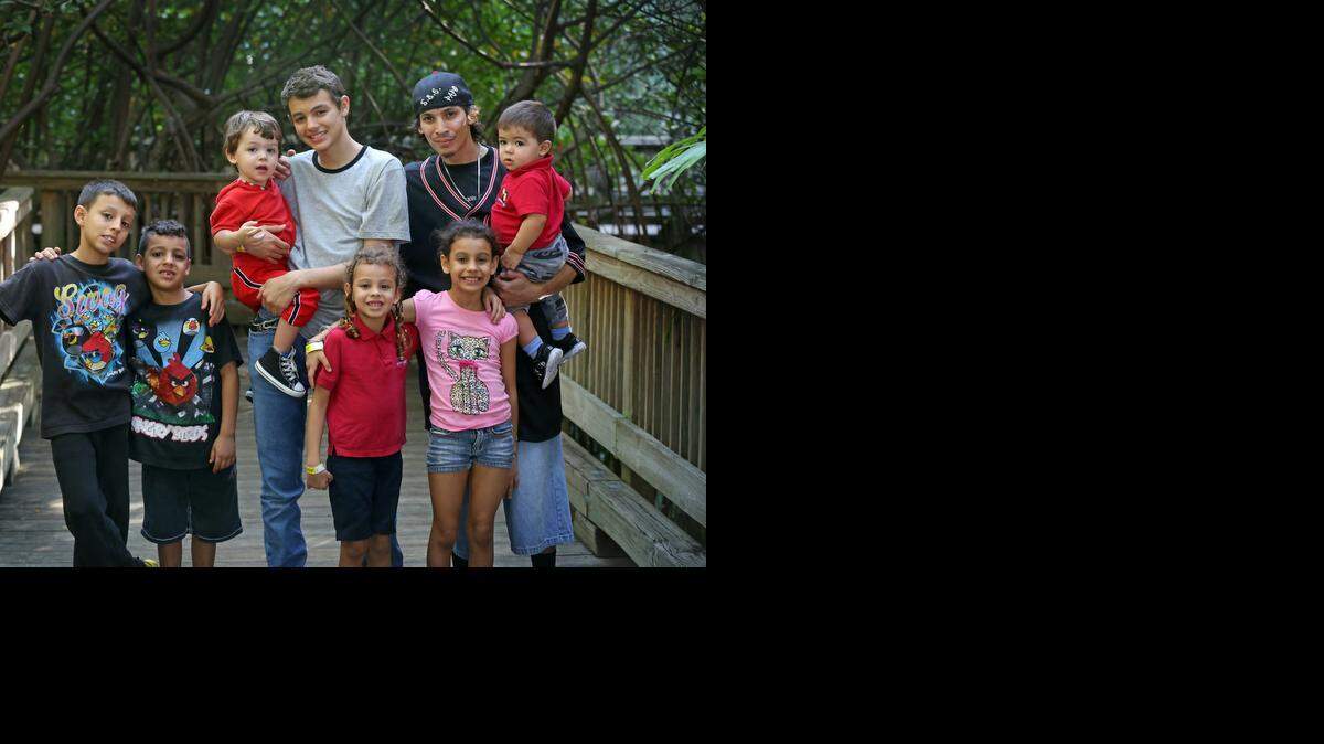 
Andres Vasquez brings his seven children to Jungle Island on Dec. 23. The visit was courtesy of Jungle Island, which also treated other Wish Book recipients to an afternoon at the Miami attraction. Vasquez cares for all of his children. The family, from left: Christopher, 9, and Alvin, 6, Adrian, 2 being held by Andres, Jr., 14, sisters Christine, 5, and Cymayra, 8, and father Andres with baby Dorian, 1.
