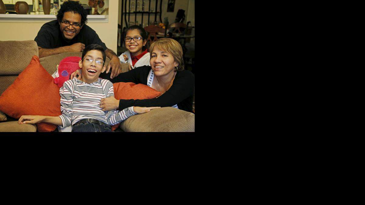 
Michael Angelo Ruiz, center, 16, of Miami Gardens, with his parents Migueland Juanita Ruiz and his 12-year-old sister, Andrea Michelle. Michael has cerebral palsy and needs a special restraint seat to travel safely in a car, but his family can’t afford it.
