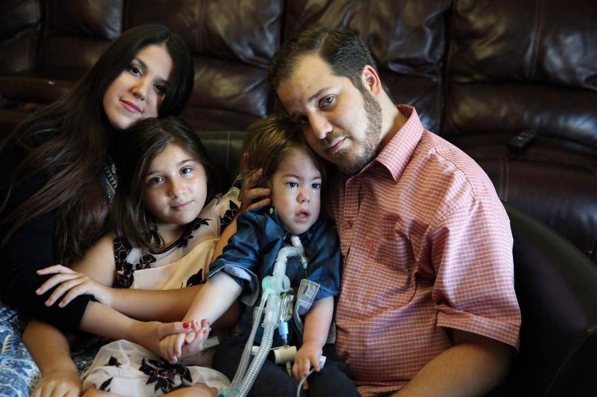 Javier and Jessica Gonzalez, with their 20-month old son JJ (Joshua Jacob), and their 9-year old daughter Bella in their Miami home that suffered roof damage from Hurricane Irma. JJ has a rare genetic disorder, x-linked myotubular myopathy, that weakens the muscles in his body, including his diaphragm and throat.