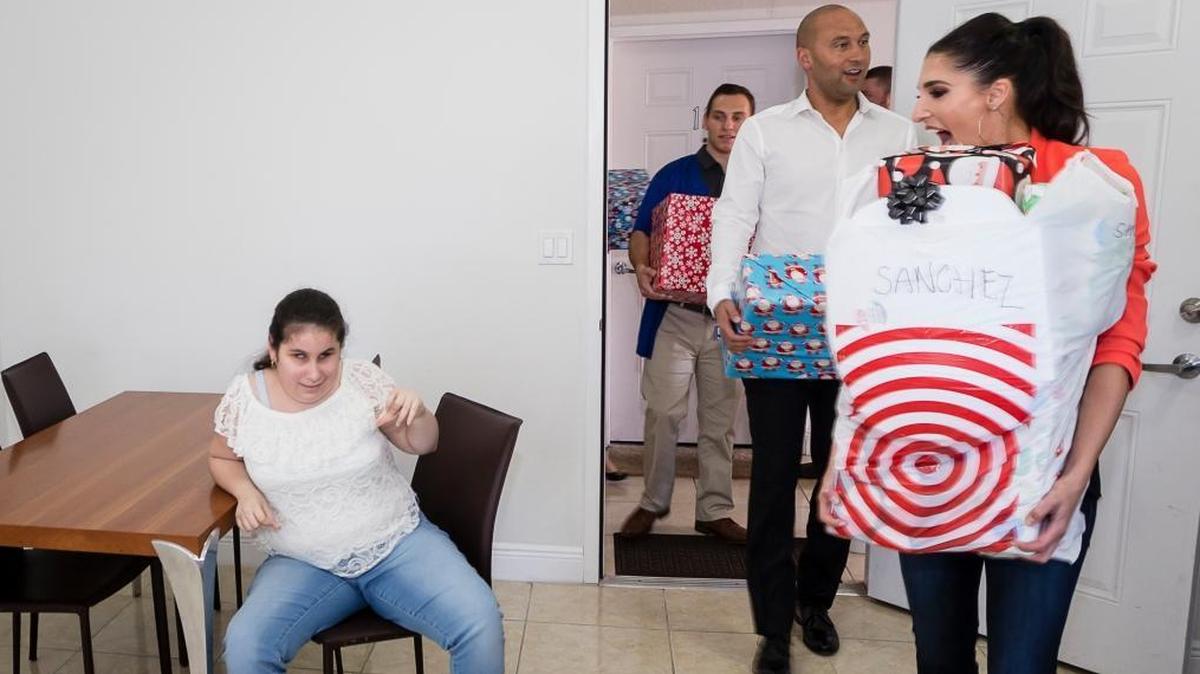Carrying Wish Book gifts, Marlins Foundation staff, including Derek Jeter, drop by Katherine Sanchez’s home in Miami.