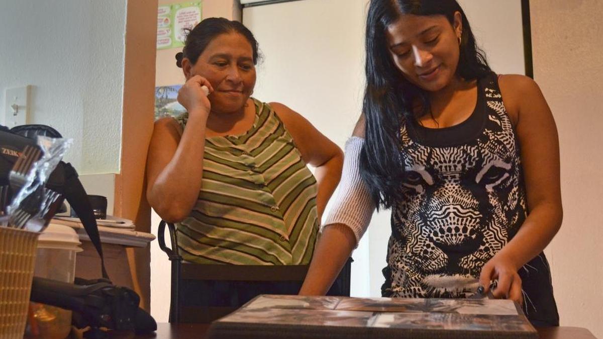 Delmes Velasquez and her mother, Ines, look over family photos in their Homestead apartment. Ines has four children, two of whom have Cystic Fibrosis, a genetic, incurable and degenerative disease. Two of her kids are also blind. Her eldest daughter, Delmes, serves as the family caretaker.