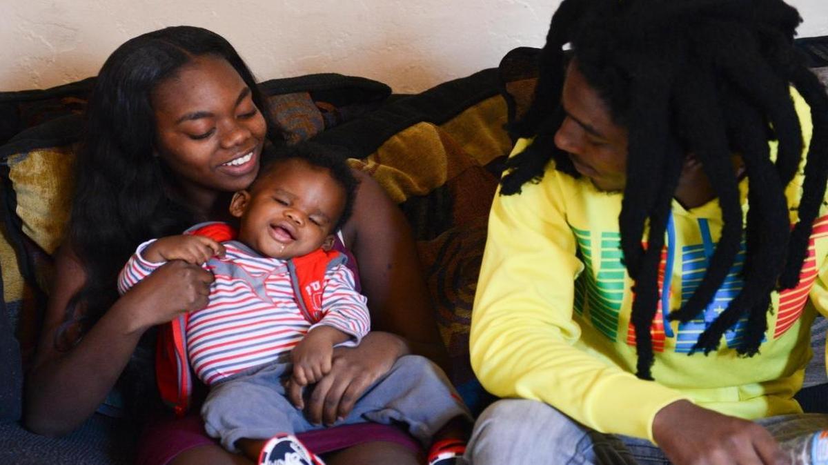 Shamiska Miller, 20, plays with her son, Brandon Boyd Junior, 1, as Boyd's father, Brandon Boyd, 20, watches in Miller's mother’s living room on Dec. 11. Boyd Jr. was born without eyes because of Anophthalmia.