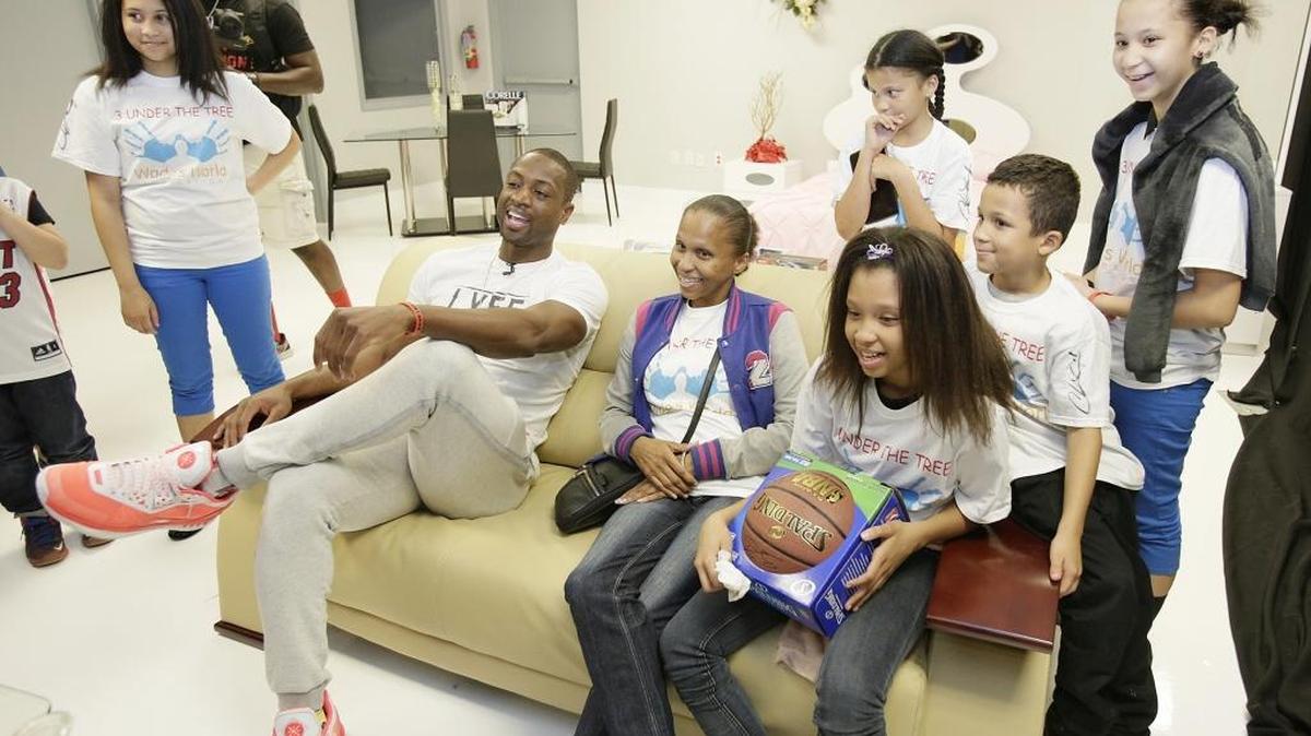 Miami Heat player Dwyane Wade and Mendez family, one of the three of the Wish Book families selected to attend Wade's World Foundation and the Miami Herald Wish Book Christmas party, tries out their new couch at Global Furniture warehouse on Saturday, Dec. 19, 2015 in Miami Gardens.