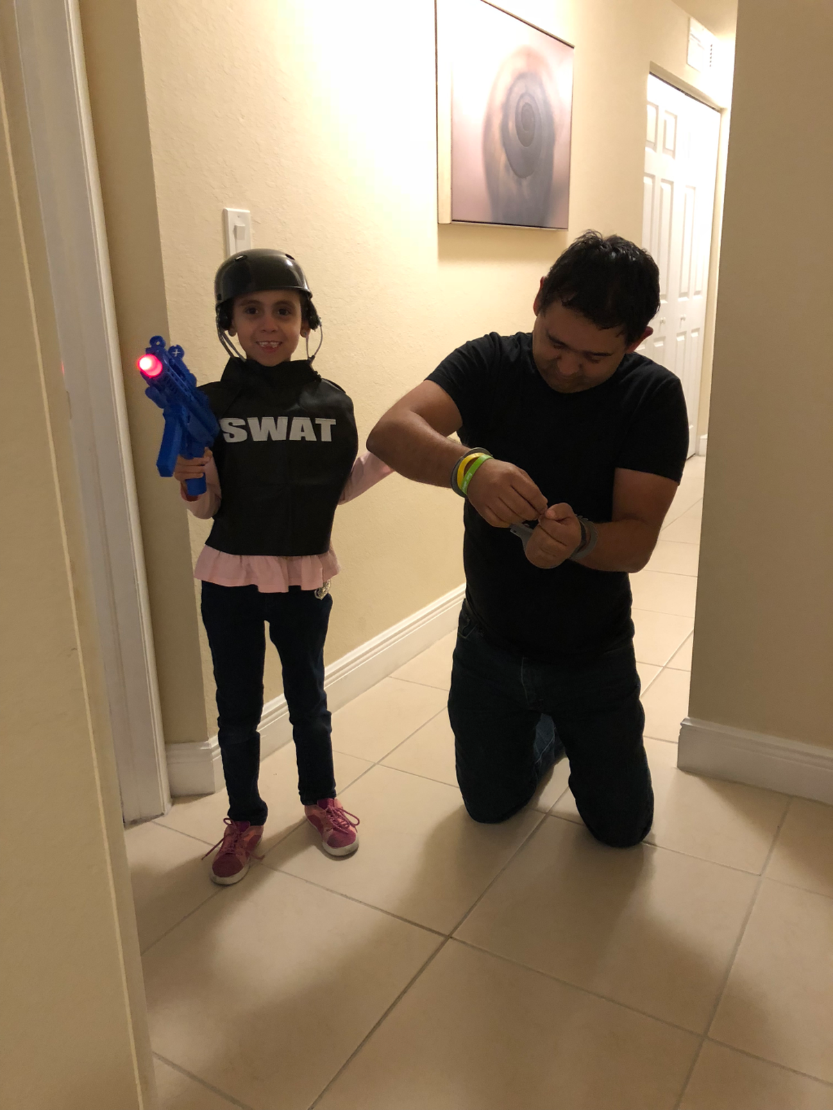 This Halloween Danna dressed up as a SWAT team agent and is pretending to arrest her father, Juan Flores, in this photo.  She wants to be a police officer when she grows up.