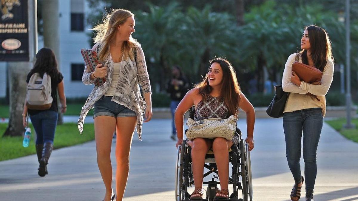In 2013, Jazzmin Peluchette was diagnosed with an extremely rare disease called neuromyelitis optica (NMO). NMO is an autoimmune disorder with an unknown cause. She suffered an exceptionally severe seizure rendering her quadriplegic, blind in both eyes and intubated. She battled for her life for the first 17 days. Today, Jazzmin, seen here with two of her roommates, Janine Wettergren and Karina Azevedo, is doing well at FIU as a junior and has regained all but her legs' mobility.