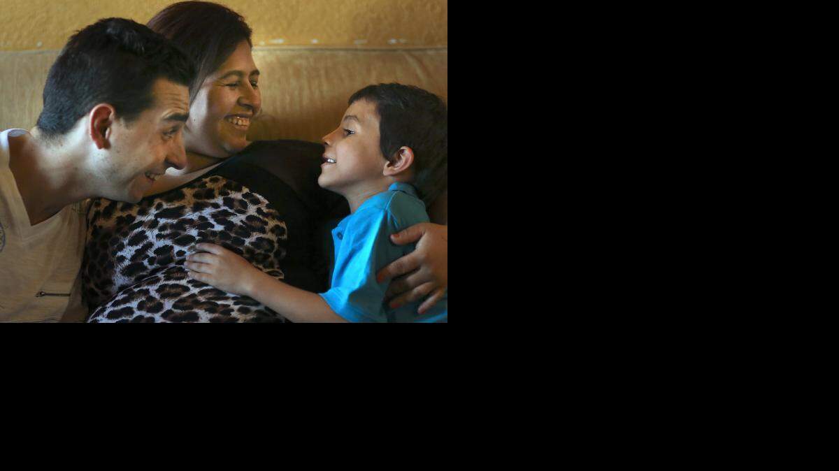 
SMILES: Joel Diaz and Belkis Johana Mairena have a smile session with their younger son, Emanuel Diaz-Mairena, 6, on Thursday, Oct. 30, 2014 in their rented home in Miami. Their older son is Richard Diaz-Mairena, 8. In July, Emanuel was hit by a car while playing ball in the street with Richard. Emanuel suffered traumatic brain injury, was in a six-week coma, and had a seizure. He has recovered more than his doctors expected but still has memory loss and difficulty with moving his left arm and leg. 
