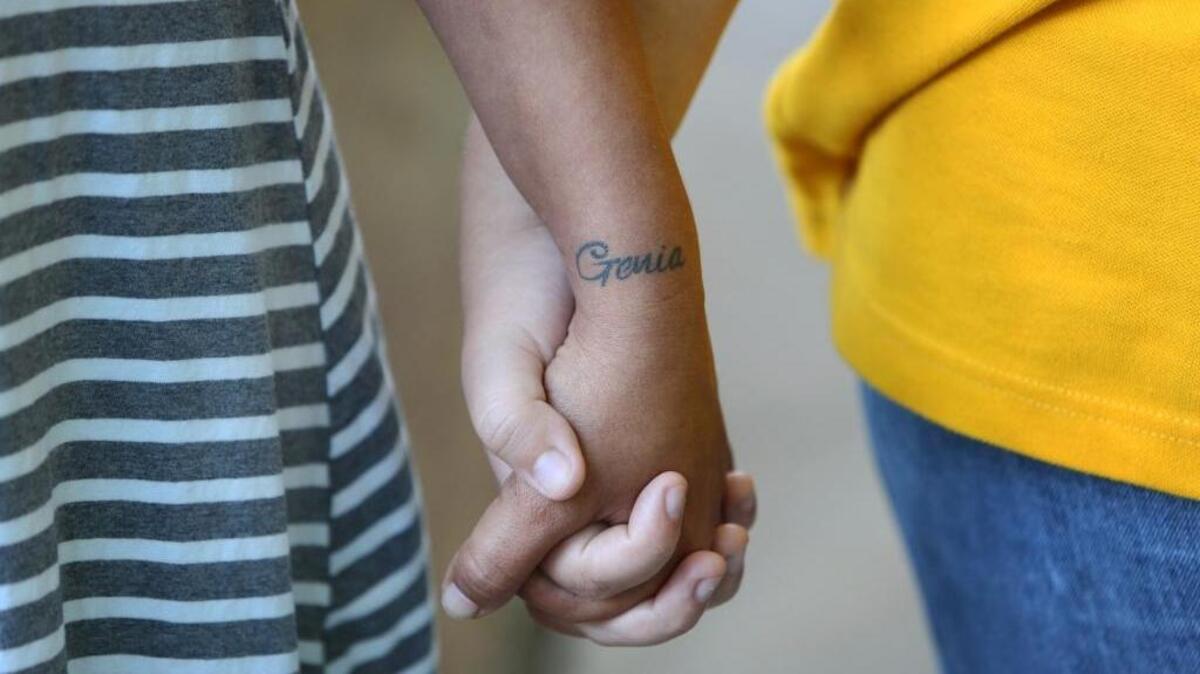 Michelle Vega holds her 16-year-old daughter’s hand. The two have been through some very hard times together. They said they are survivors of years of domestic abuse.