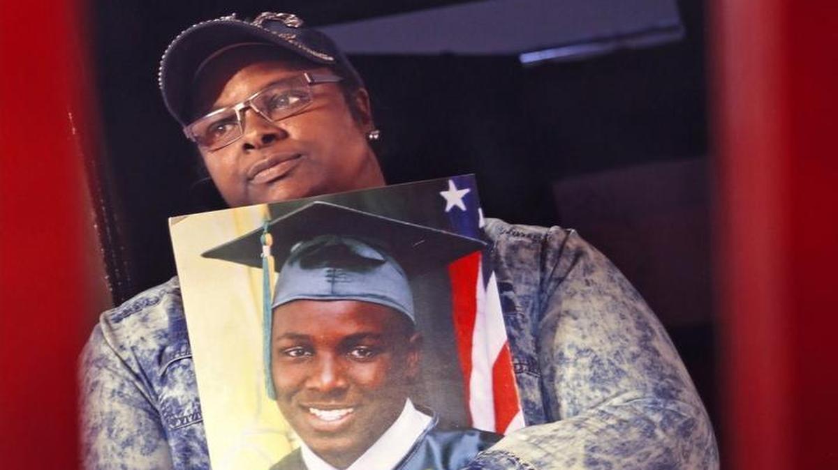 Sherita Small is shown at her home in Miami, holding a photo of her murdered son, Zamari. Zamari, who was 16, was shot and killed in 2014 in a case that still remains unsolved. She moved away from Miami Gardens, where the shooting happened, but she still deals with depression and has trouble sleeping.