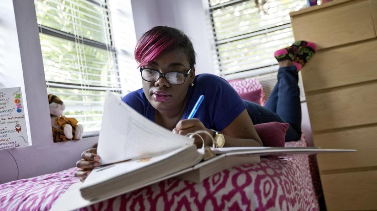 Colesha Courmier 20, studies in her tiny apartment. Colesha, who hopes to become an attorney and one day open her own restaurant, is aging out of foster care.