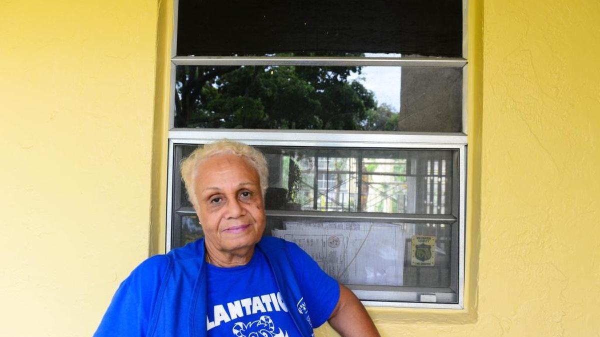 Yvonne Simpson, 75, stands in front of a window outside of her burned-out apartment on Dec. 4, in Plantation. She is a foster grandparent at Plantation Elementary.