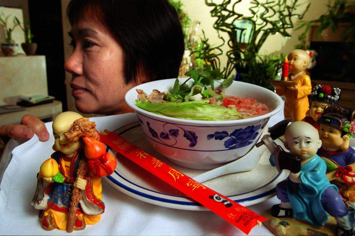 Thursday 01/16/02 - Richard Patterson/for the Herald 0 Sue Yee Ho, a waitress at Little Saigon, a Chinese and Vietnamese Restaurant, located on 16752 N. Miami Avenue, serves a bowl of soup surrounded by several toy figurines that are sold at the front counter of the restaurant. Toys, video games and bamboo plants are among the other unique items sold to the customers on a daily basis.