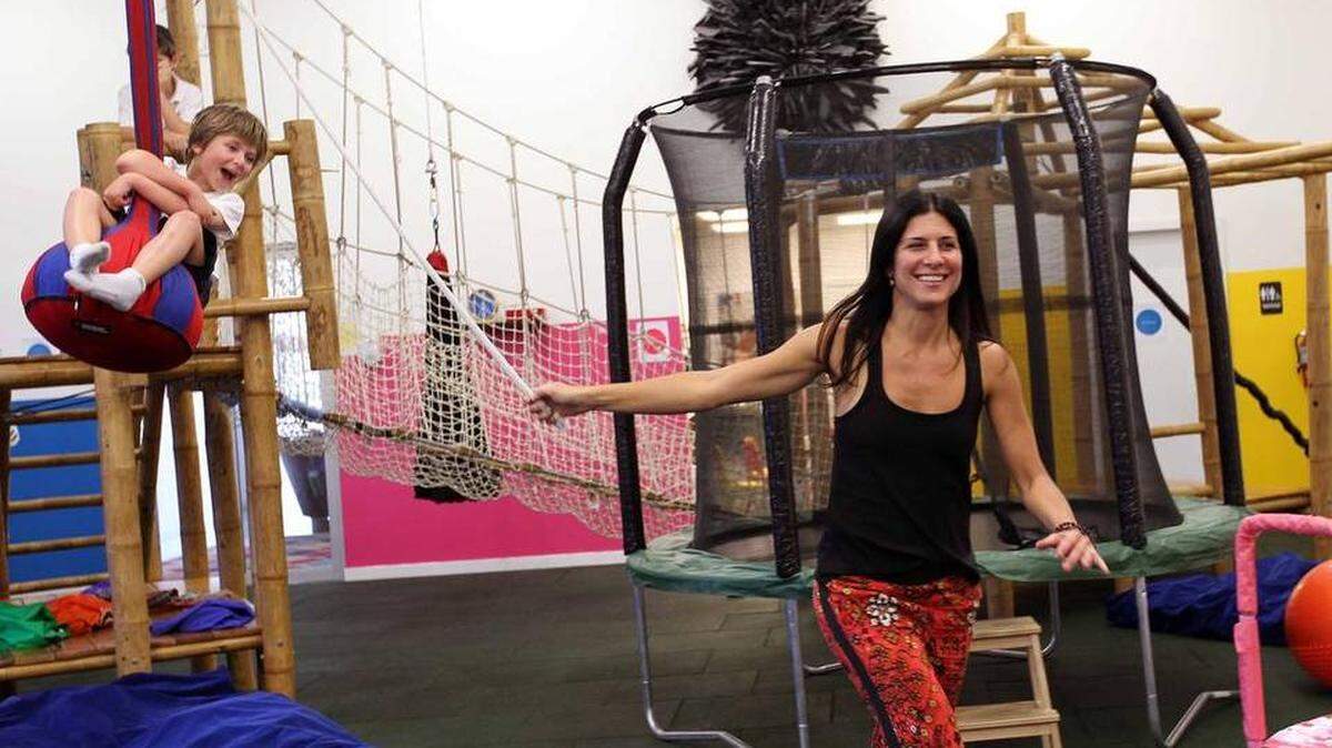 La directora y fundadora de Playground Play-In Miami Nina, Ginatta (der.), juega con el pequeño William Safir.