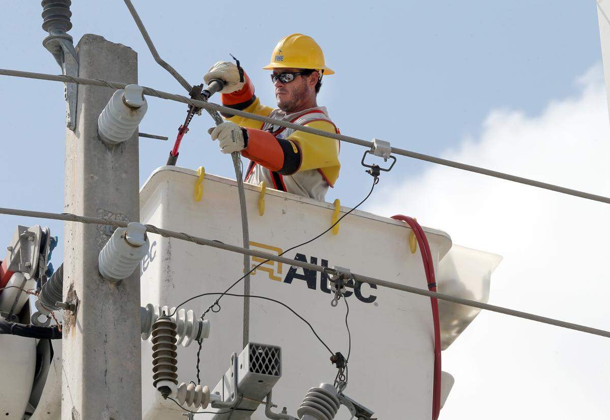 Lineman Titus Beaumonan, with Pike company working with FPL reconnects  a main power line at the intersection of !37 Ave and 140 Street in Kendall a day after Hurricane Irma left South Florida heading to the West coast, on September 11, 2017.