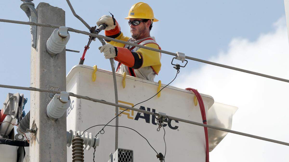 Lineman Titus Beaumonan, with Pike company working with FPL reconnects  a main power line at the intersection of !37 Ave and 140 Street in Kendall a day after Hurricane Irma left South Florida heading to the West coast, on September 11, 2017.