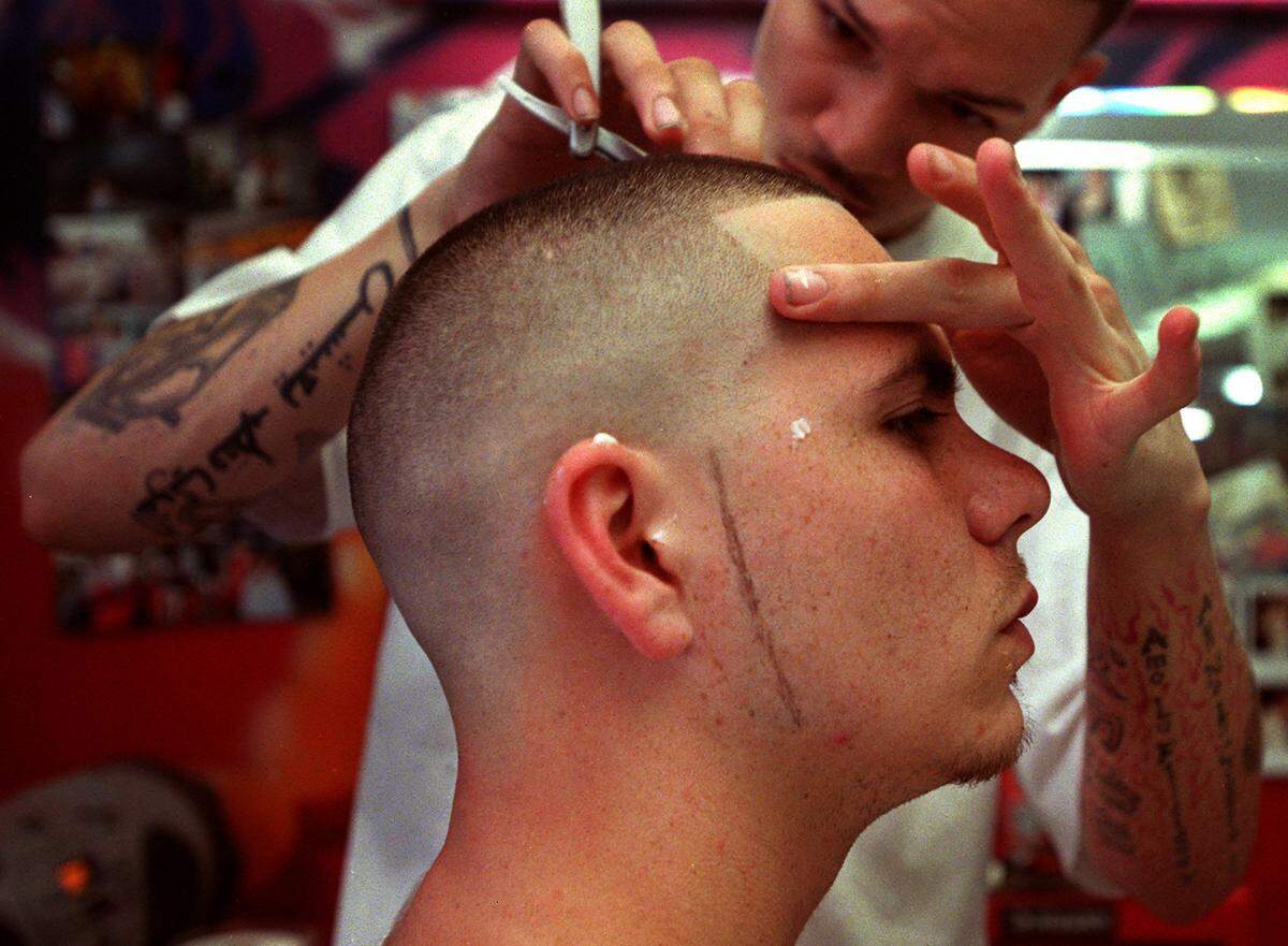 01/30/03 -- Barbara P. Hernandez / For the Herald -- Miami: Up and coming rapper, Pitbull, getting a haircut at his favorite barber shop, a grafitti-walled Little Havana hub whre you can get a 12-dollar fade cut. His barber, 20-year old Josue Romero, is the son of the owner, and they have known each other for some years. (1 of 2)