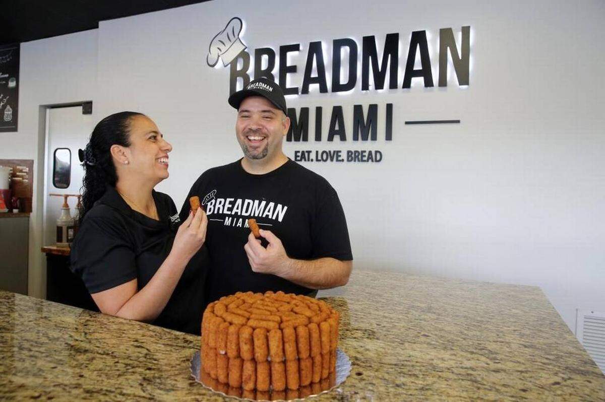Jessica and Andy Herrera, owners of Breadman Miami bakery in Hialeah, pull croquetas off of their popular Croqueta Cake to taste. The unique cake is becoming a popular item at the bakery. Herrera calls the cake ‘a marvel of engineering,’ as it is built using 100 croquetas and toothpicks