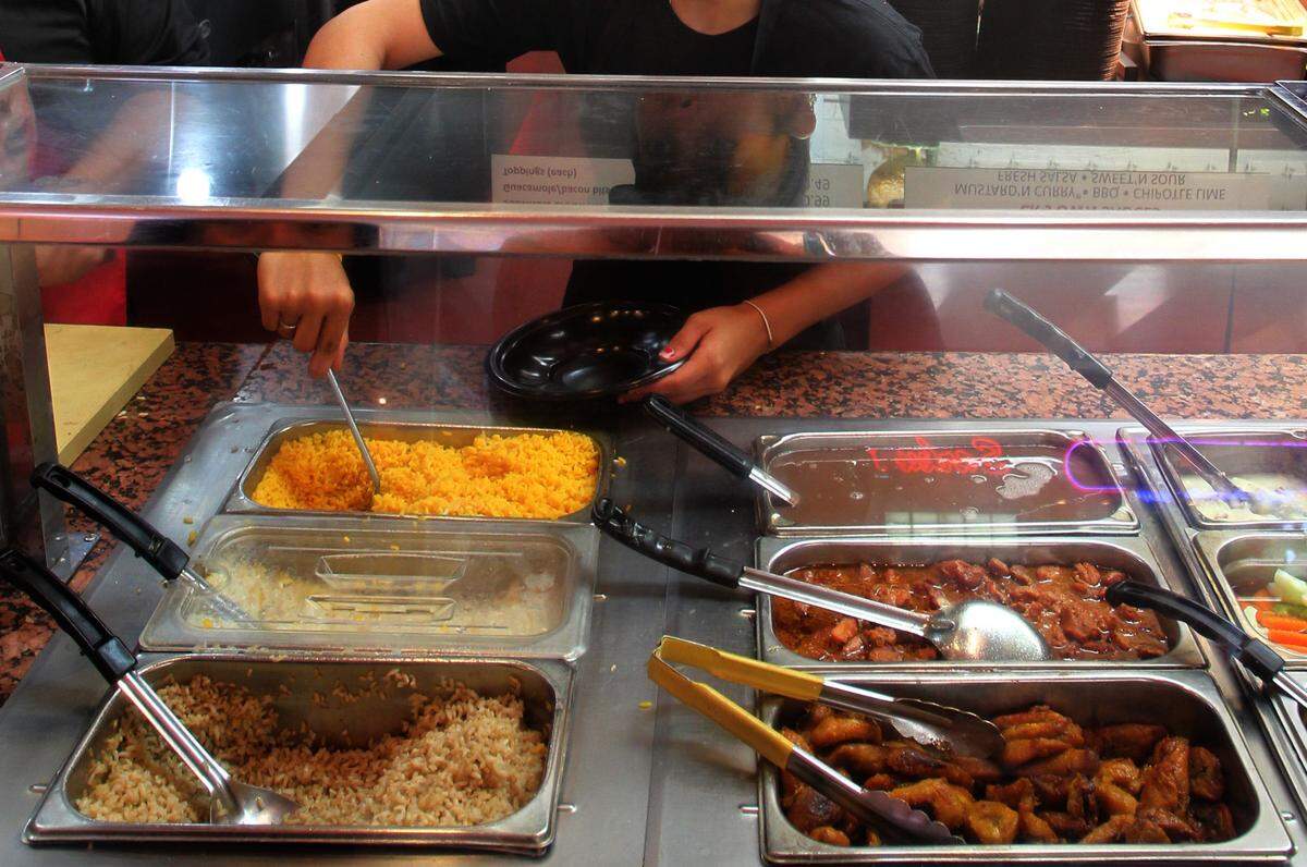 Lara Torres dishes out a plate for a customer at Chicken Kitchen in the food court at the Aventura Mall on June 24th, 2010. For story on teen Jobs.