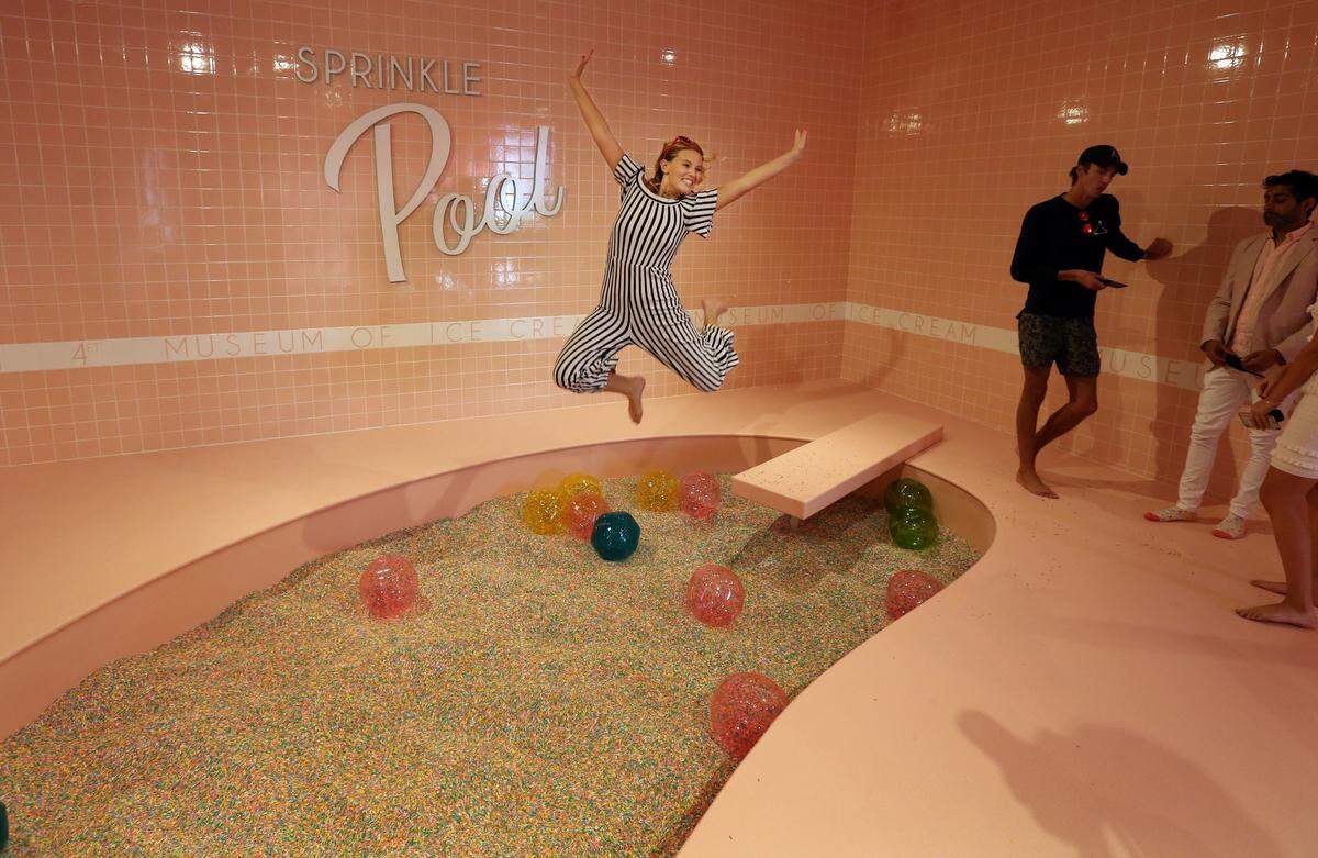 Carlen Dickerson with University of Miami TV jumps off the diving board into the Sprinkle Pool filled with 100 million non-edible, colorful sprinkles at first Museum of Ice Cream in Miami Beach in 2017. The new pop-up will also feature the sprinkle pool.