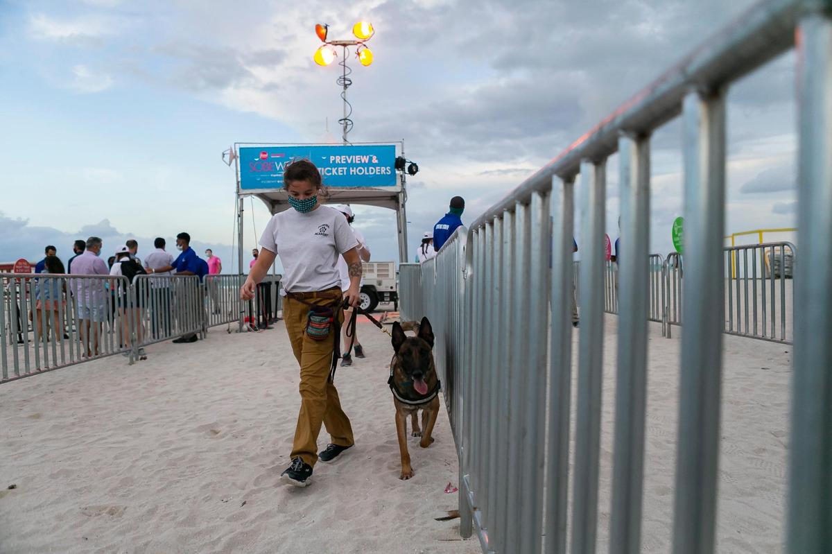 Brooke Whitstine, a K9 handler, and her COVID-19 detection dog, Stryker, are stationed at the entrance of the South Beach Wine and Food Festival Italian Bites on the Beach.
