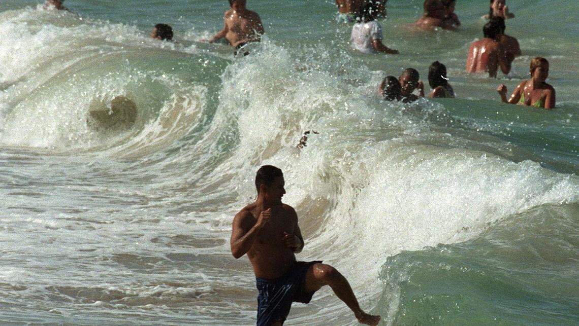 Beach goers play in the waves at Sunny Isles beach.