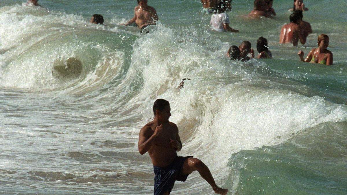 Beach goers play in the waves at Sunny Isles beach.