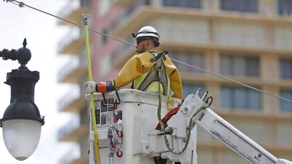 An FPL-contracted worker reconnects a main power line on Collins Avenue on Sunny Isles Beach on Tuesday, September 12, 2017 in Sunny Isles Beach.