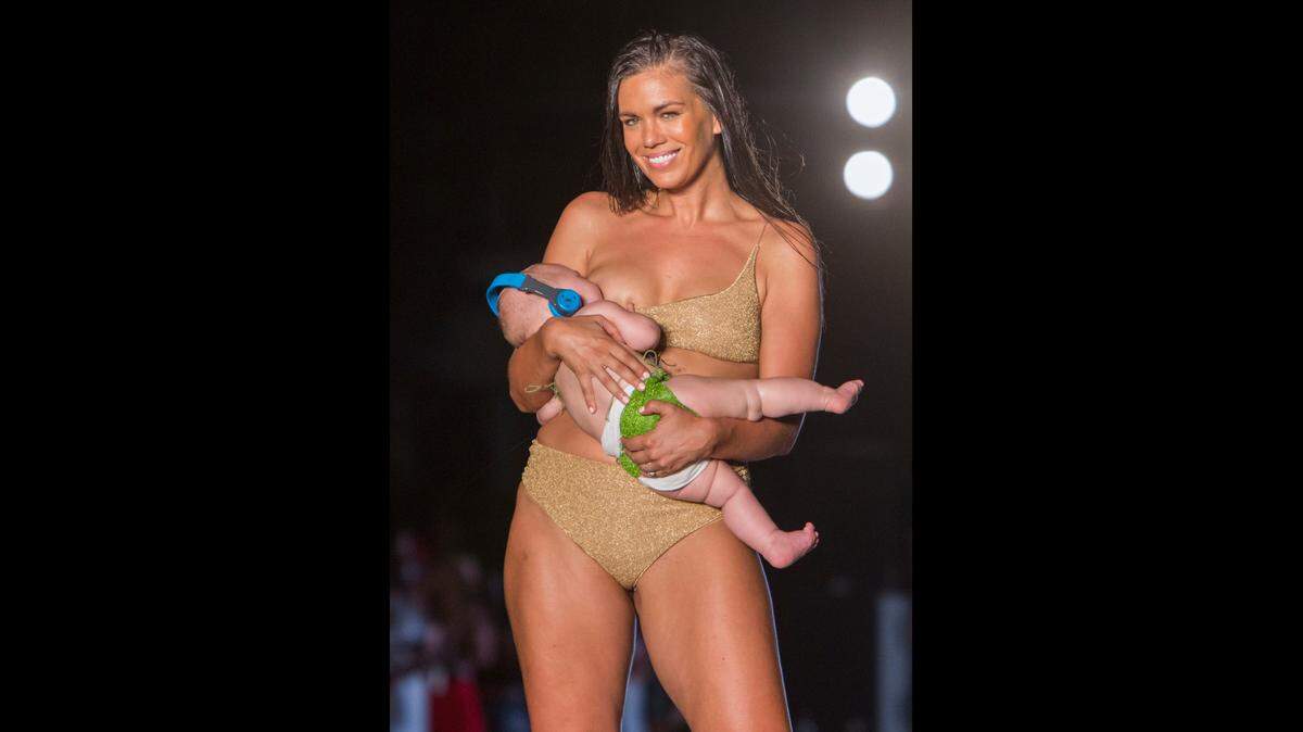 Model Mara Martin walks the runway while breastfeeding her baby for the 2018 Sports Illustrated Swimsuit show at PARAISO during Miami Swim Week at The W Hotel South Beach in Miami Beach, FL, on July 15, 2018.
