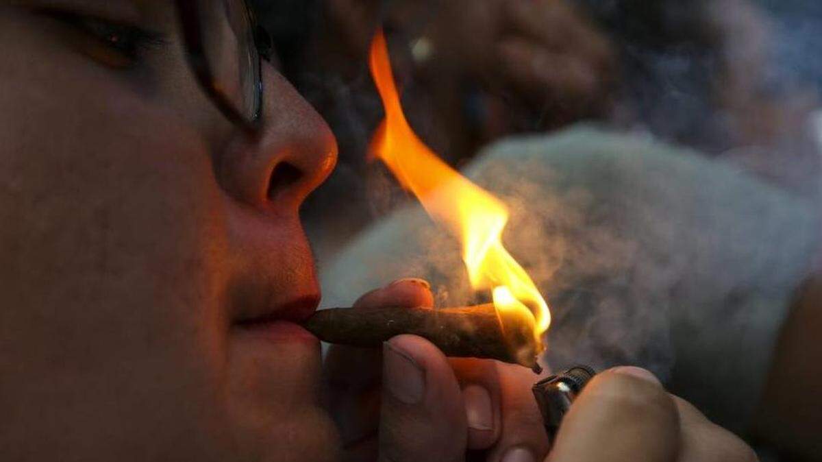 Robert Whitaker, 18, from Hammond, Louisiana, lights a joint while Curren$y performs during the first day of the Rolling Loud Festival in downtown Miami on Fri., May 5, 2017.