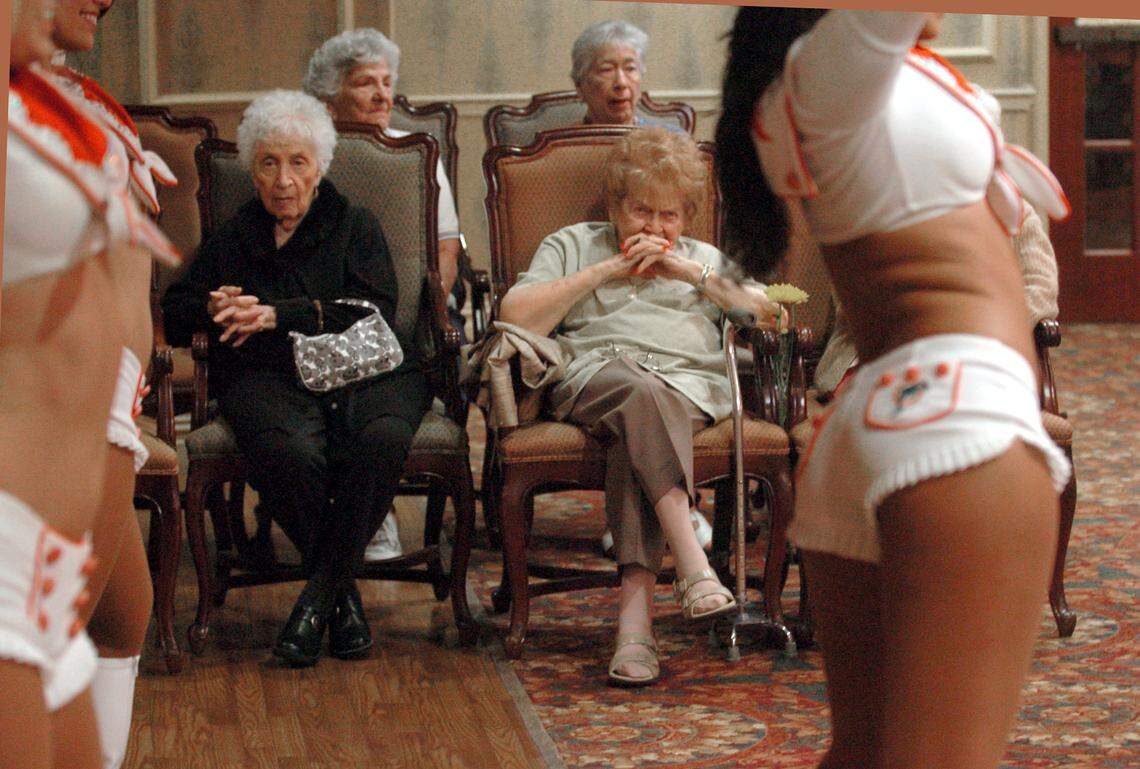 09/08/07 Miami Herald photo by Peter Andrew Bosch. Miami. Dessie Buschel (left in black) and Beatrice Ross (right with hands on her face)  look's on as the Miami Dolphins Cheerleaders visited the Palace Suites retirment coummunity to celebrate the opening of the Dolphins football season.