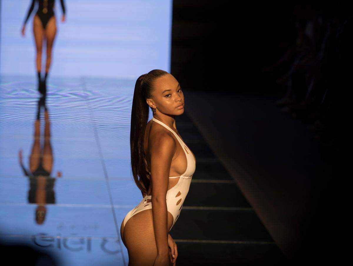 Fashion models wear swimwear designed by Gigi C Bikinis on the runway at Miami Swim Week in Miami Beach on July 14, 2018. 18-year-old Gigi Caruso is the youngest designer to show in Miami Swim Week history.