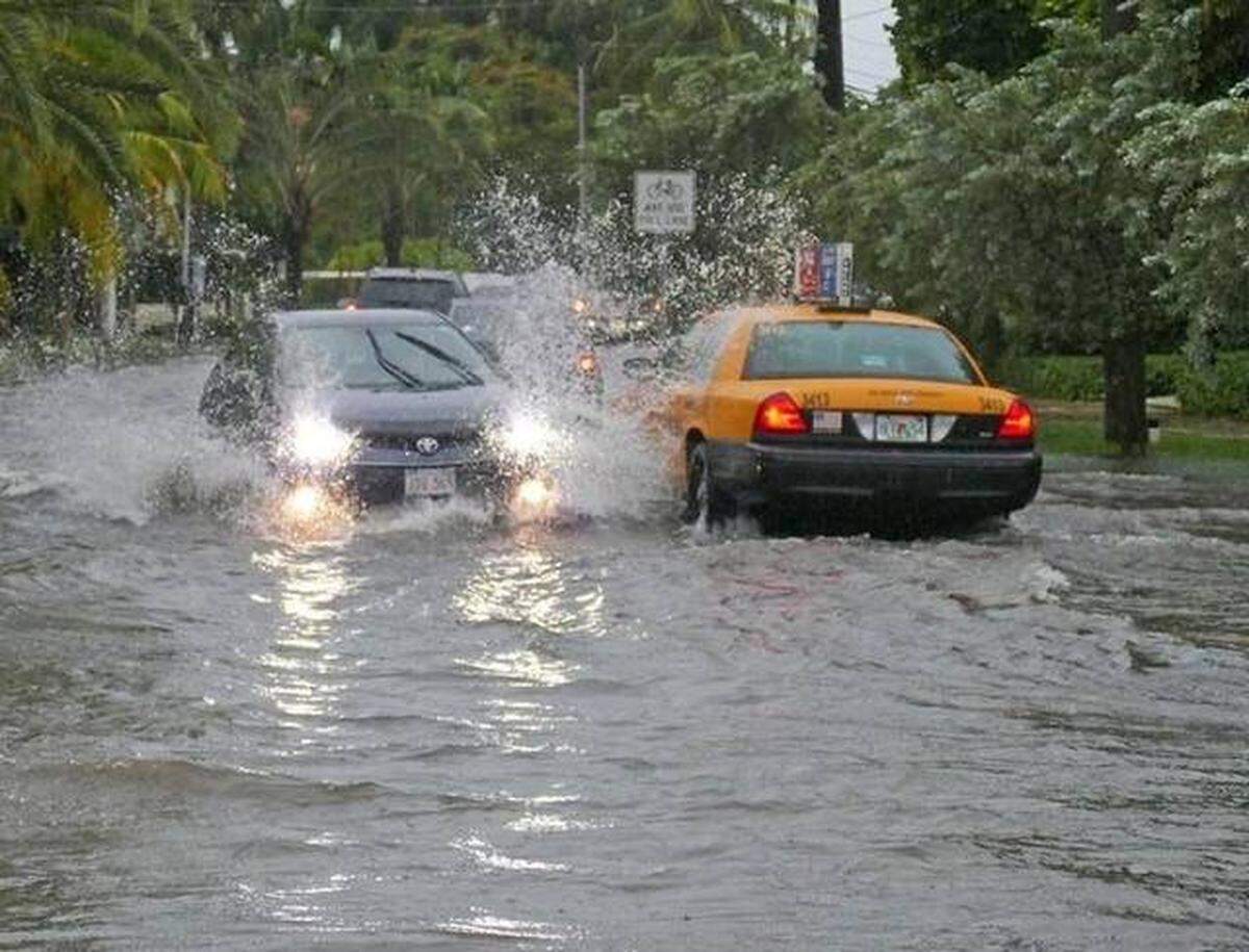 Cars goes through a flood caused by heavy rains at North Bay Road and West 21st St. in Miami Beach on Tuesday, Aug. 1, 2017. Miami Herald file