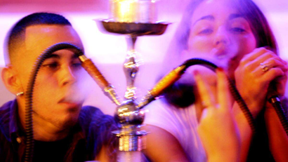 Carlos Fuentes and Danielle Gonzalez smoke from a hookah at Oasis Cafe in Coconut Grove. Photo: Ronna Gradus
