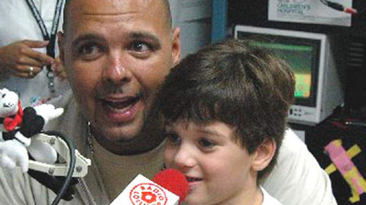 Gabriel Ponce helps Power 96's DJ Laz sing happy birthday to Radio Lollipop at Miami Children's Hospital.