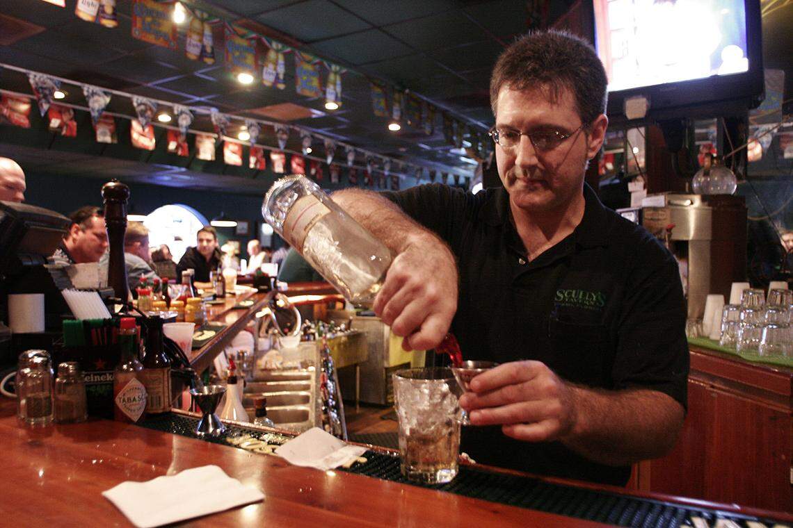 Bar tender Joey Kernisky prepares a double of captain and coke for a customer at Scully's Tavern in Kendall on a Friday night. Kernisky has worked at the restaurant for 6 years and played an instrumental part in helping to prepare the tavern for it's feature spot on Guy Fieri's Food Network show Diners, Drive-ins and Dive's. (Kendall, 4 of 5)
