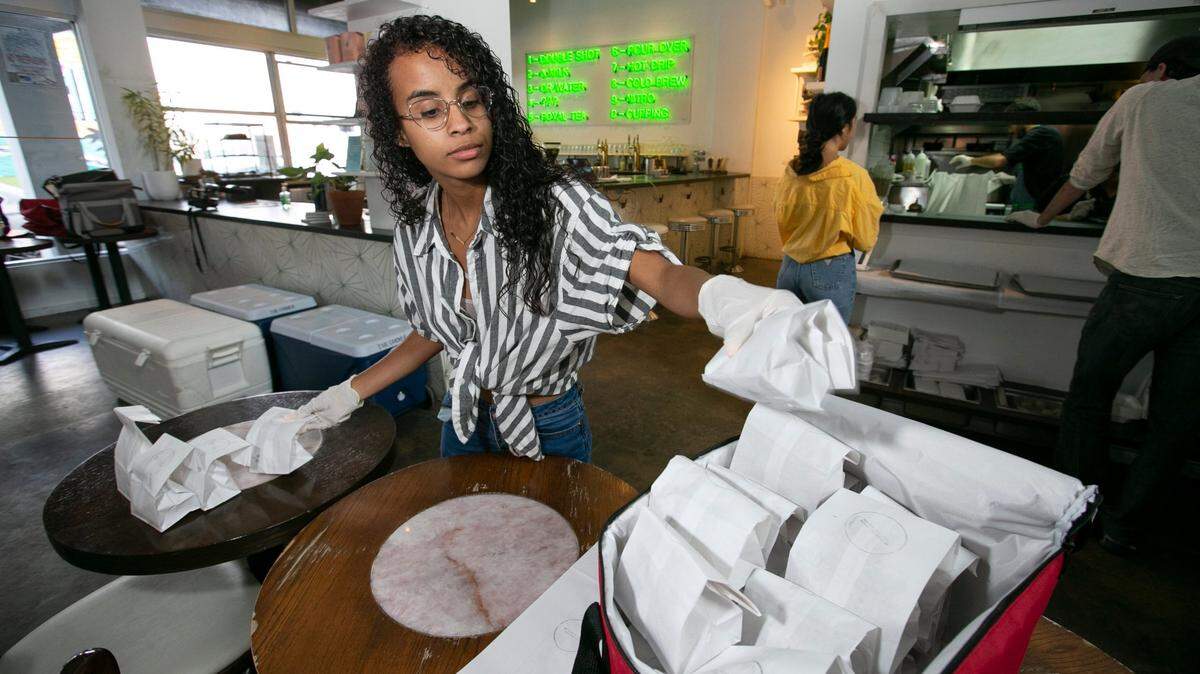 Virginia Vasquez prepared a delivery of food at All Day, a coffee shop and restaurant in downtown Miami in this photo from March 2020, when All Day pivoted to delivery only and selling groceries. A year later, even after reopening, owners have been struggling to rehire staff for their restaurants.