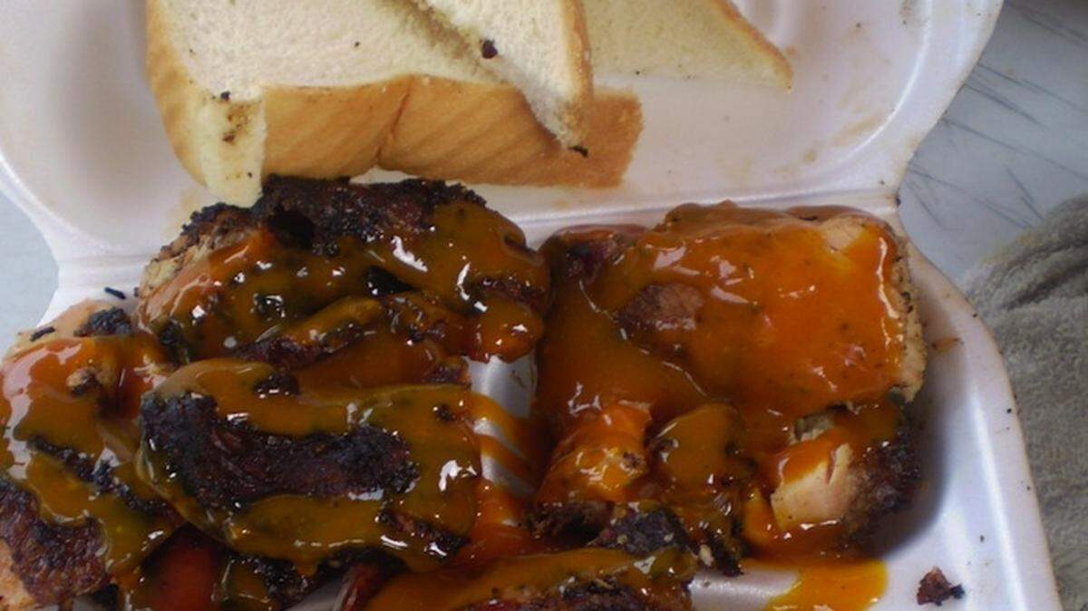 The Bo Legs BBQ sampler with dark meat chicken barbecue, jerk chicken and ribs all smothered in honey mustard sauce at the mobile trailer stationed in the parking lot of Foxy Lady Laundry on 167th Street, North Miami Beach.