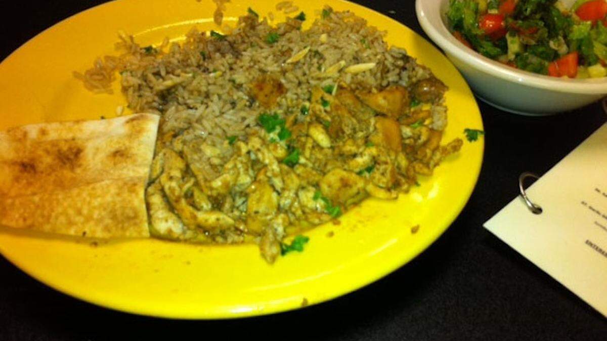 PLANTATION: Baraka's chicken plate comes with rice studded with sliced almonds and a small chopped salad.