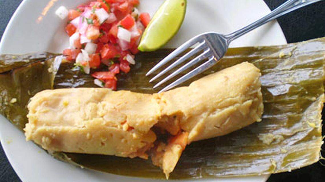 Hand patted cornmeal tamale stuffed with chicjen, carrots and potatoes steamed in a banana leaf wrapper at El Tamarindo Restaurant and Coal Fire PIzza in Hollywood. Photo: Linda Bladholm.
