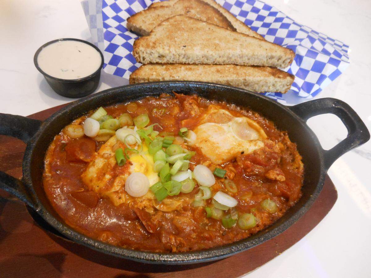 Shakshuka, two sunny-side-up eggs cooked in a thick, flavorful tomato sauce is the specialty of the house.
