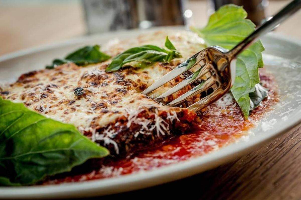 Fi’lia is a place for palates both adventurous and risk-averse: You can build a meal of Caesar salad, margarita pizza and chicken Parmesan, pictured here. Handout